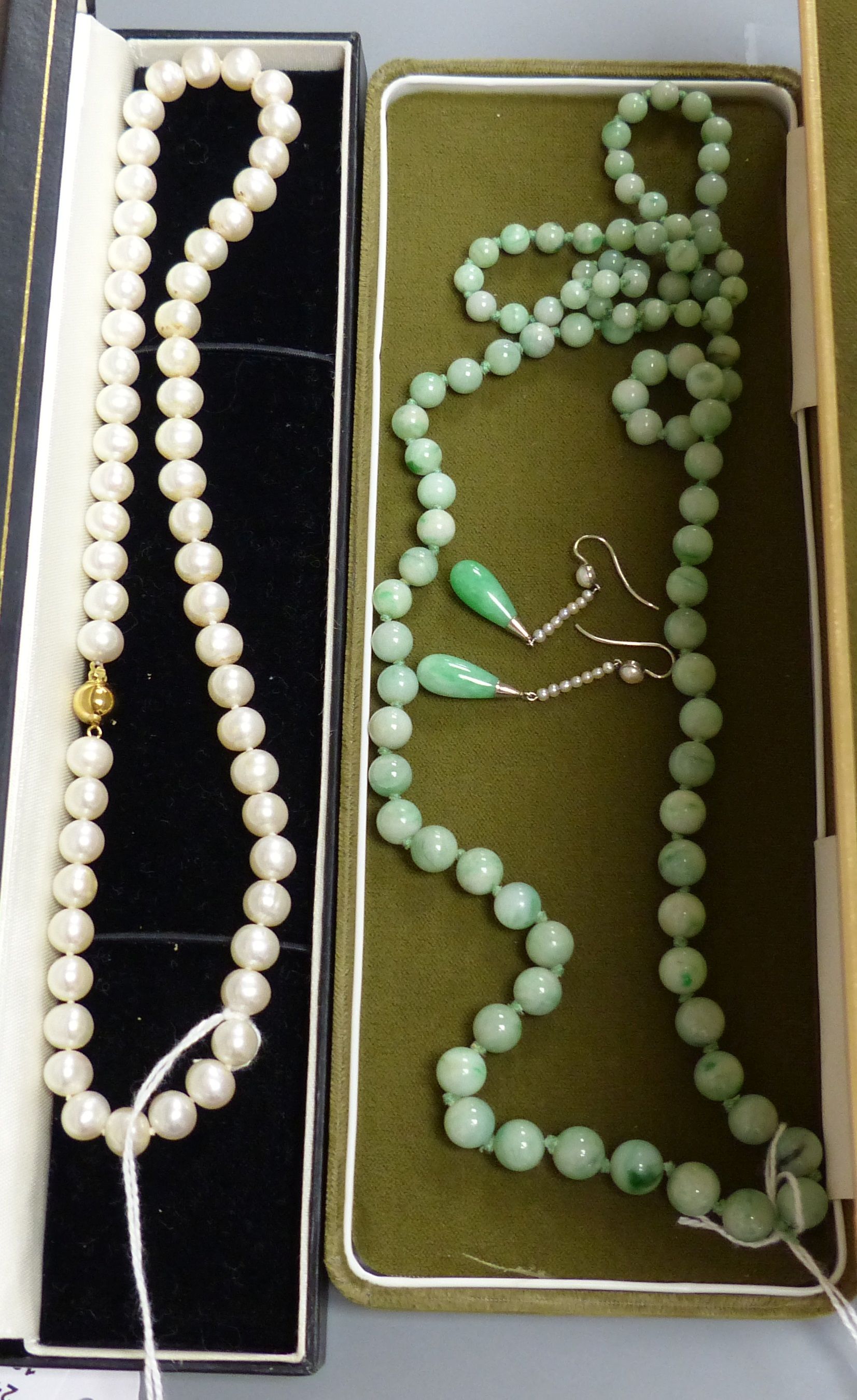 A single row uniform cultured pearl necklace with 9ct gold ball clasp, a graduated jade bead necklace and a pair of jade and seed pearl drop earrings, 37mm